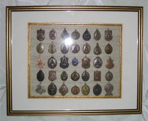 collection of small buddha medals - one of two framed sets